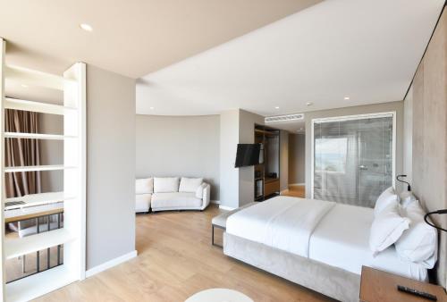 a bedroom with a white bed and a living room at Yacht Hotel in Vlorë