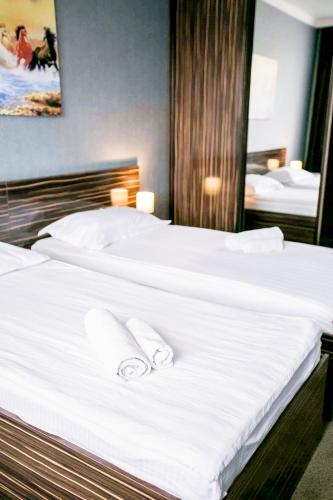 a large white bed with two white towels on it at Premier Inn Astana in Astana