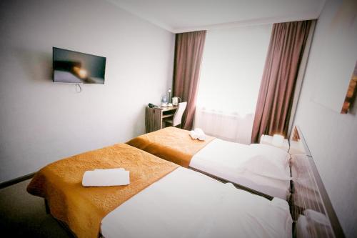 a hotel room with two beds and a window at Premier Inn Astana in Astana