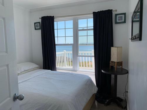 a bedroom with a bed and a large window at Chalet chez les Petit in Grandes-Bergeronnes