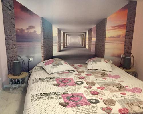 - une chambre avec 2 lits et un tableau mural dans l'établissement Le Gîte de Brigitte !, à Saint-Dié-des-Vosges