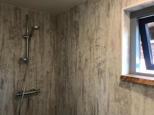 a shower stall in a bathroom with a window at Heerlijk huisje vlakbij de duinen van Oostvoorne in Oostvoorne