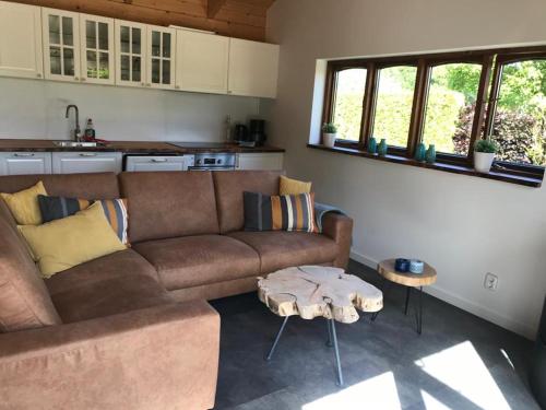 a living room with a couch and a table at Heerlijk huisje vlakbij de duinen van Oostvoorne in Oostvoorne