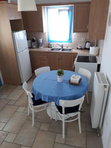 a small kitchen with a blue table and chairs at S & K Maisonnettes in Pounda