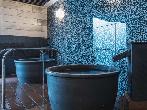 a bathroom with a large tub and a blue wall at APA Hotel & Resort Ryogoku Eki Tower in Tokyo