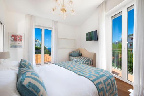 um quarto com uma cama e uma grande janela em Luxury Home Sea View & Jacuzzi in Sorrento centre em Sorrento