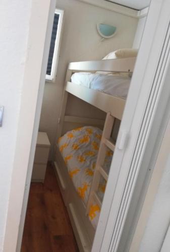 Cette petite chambre comprend 2 lits superposés. dans l'établissement Les Arènes - Port Leucate - Une chambre - Terrasse - Proche Commerces - Tout confort, à Leucate