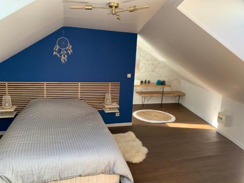 a bedroom with a blue accent wall and a bed at Duplex plein centre ville 3Etoiles in Le Mont-Dore