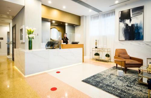 a woman standing in a lobby with a mirror at Berkeley Shore Hotel in Miami Beach