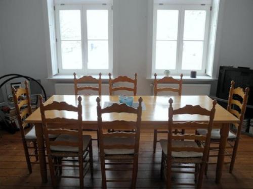 a dining room with a wooden table and chairs at Gutshaus Thorstorf FeWo Travemünde in Warnow