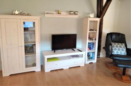 a living room with a tv and a white entertainment center at Ferienwohnung Tischneck in Schramberg