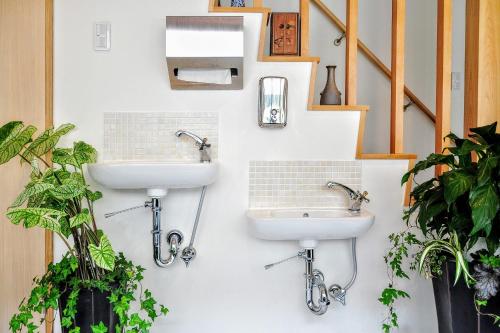two sinks on a wall in a bathroom with plants at Guesthouse Soi in Kyoto