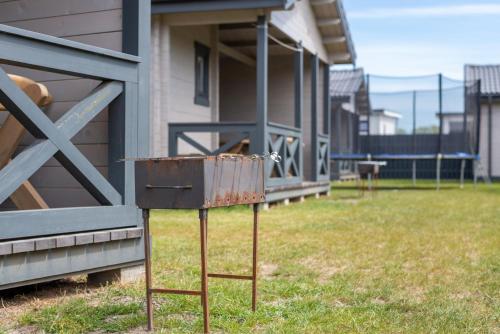 an old rusty box sitting in the grass next to a building at Vasarnamiai 2 in Šventoji