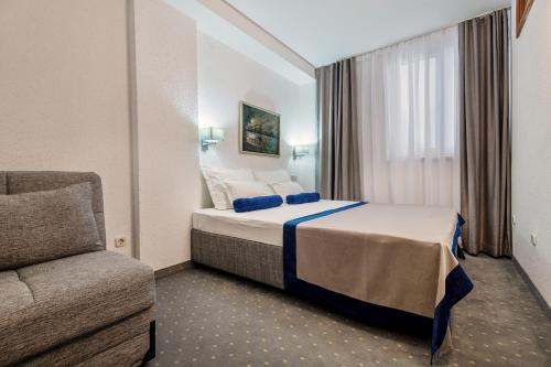 a hotel room with a bed and a couch at Apartments Tamaris in Neum