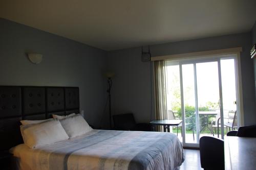 a hotel room with a bed and a window at Motel des Mariniers in Kamouraska
