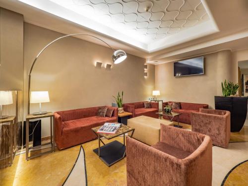 a living room with red couches and a table at Park Hotel Ai Pini & Restaurant Ai Pini in Mestre