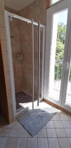 une salle de bain avec une douche avec une porte vitrée dans l'établissement La Grange, à Cazouls-d Herault