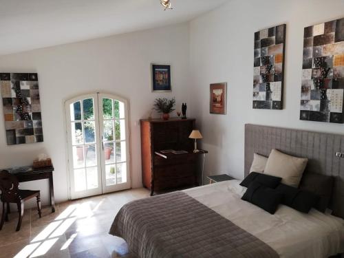 a bedroom with a bed and a desk and a window at Le Domaine Des Platanes in Bourg-Charente