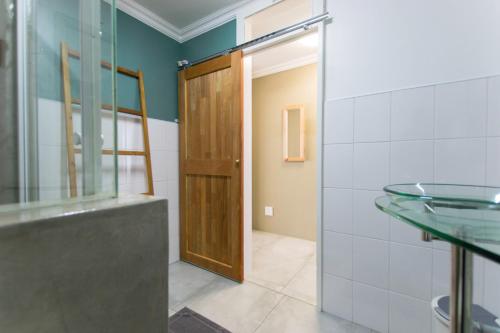 a bathroom with a wooden door and a glass doorway at Namibia Nights Accommodation in Swakopmund