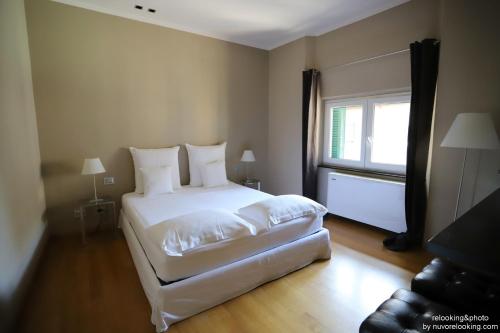 una camera con un letto bianco e una finestra di Quarto Piano Rooms a Genova