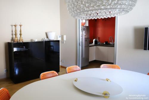 a kitchen with a white table and orange chairs at Quarto Piano Rooms in Genova