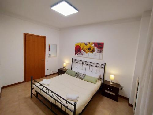 a bedroom with a bed and two night stands and a door at Tarantula Houses in Lecce