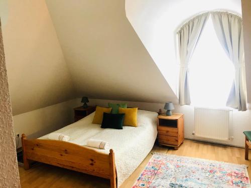 a bedroom with a bed and a large window at Corner Panzió in Szentendre