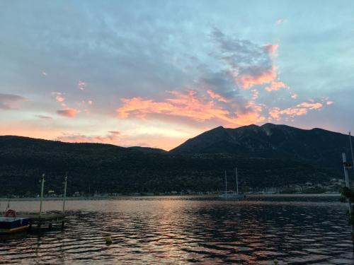 a sunset over a body of water with mountains at Camelia Studios in Yenion