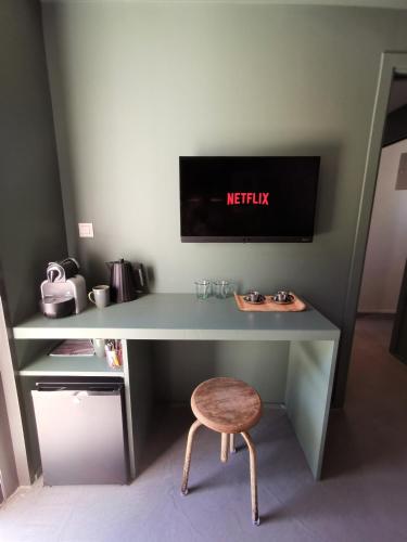 un bureau avec un tabouret et un moniteur sur un mur dans l'établissement Derrière la plage : suite, patio et pergola, au Bois-Plage-en-Ré