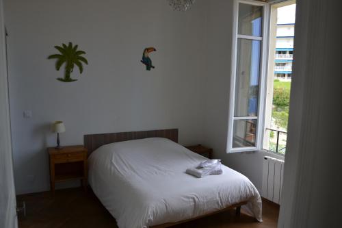 ein Schlafzimmer mit einem weißen Bett und einem Fenster in der Unterkunft Les Lauriers in Villefranche-sur-Mer