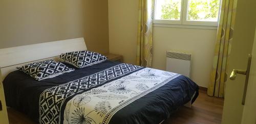 1 dormitorio con cama y ventana en COTTAGE privé avec TERRASSE et PISCINE - bord de LAC & FORÊT, en Miramont-de-Guyenne