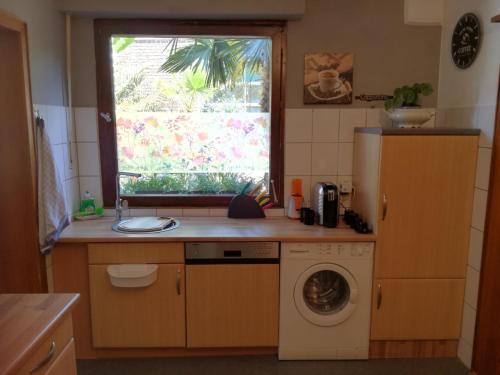 een keuken met een wasmachine en een raam bij Villakunterbunt in Nettetal