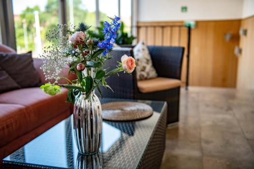 a vase of flowers sitting on a table in a living room at Hotel Zur Aue in Wesel