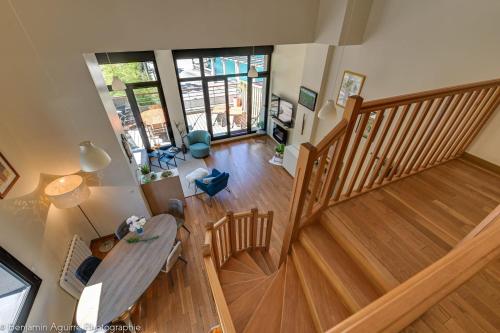 una vista aérea de una sala de estar con una escalera de madera en L'Angle du Lac - Duplex feet in the water of Lake Annecy, en Duingt
