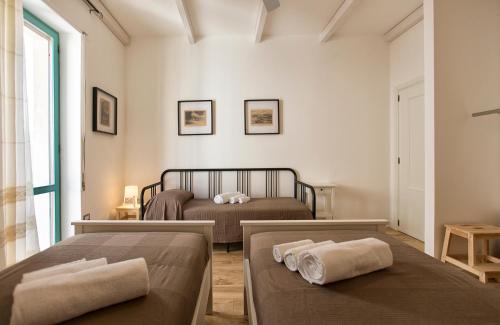 a bedroom with two beds and a window at Alghero P.Umberto old town in Alghero