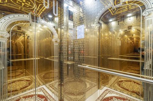 a golden elevator in a building with gold tiles at Luxury Palace Hotel in Ha Long