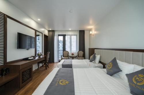 a hotel room with two beds and a television at Luxury Palace Hotel in Ha Long