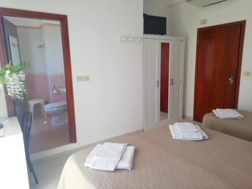 Cette chambre comprend un lit et une salle de bains pourvue de toilettes. dans l'établissement Hotel Rita, à Cervia