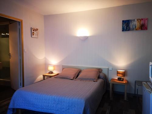 Saint-Sylvain-dʼAnjouにあるGuest House La Fauvelaieのベッドルーム1室(ベッド1台、ランプ2つ、テーブル2台付)