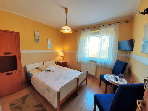 a bedroom with a bed and a table and a tv at Willa Pasat in Władysławowo