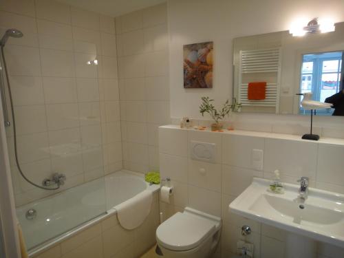 a bathroom with a toilet and a tub and a sink at Fewo31, exklusive Apartments, 2 Minuten vom Strand und Alten Strom in Warnemünde