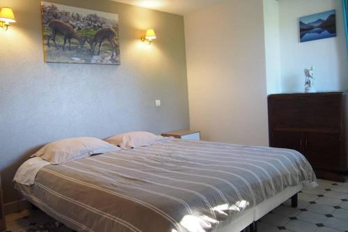 a bedroom with a bed and a picture of horses on the wall at Le Merle Enchanteur in Paladru