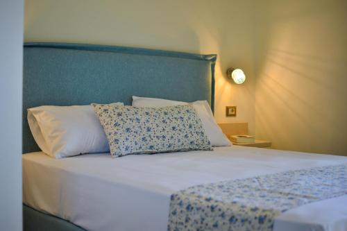 a bed with a blue headboard and a white pillow at Liogerma Studios in Trapezaki