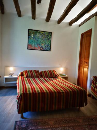 a bedroom with a bed and a painting on the wall at Guest House La Fauvelaie in Saint-Sylvain-dʼAnjou