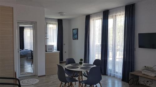 ein Wohnzimmer mit einem Esstisch und Stühlen in der Unterkunft Guesthouse Odesos in Sozopol