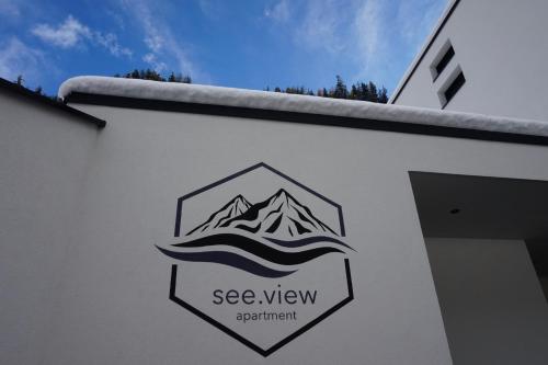 a sign on a building with a mountain on it at see.view apartment in See