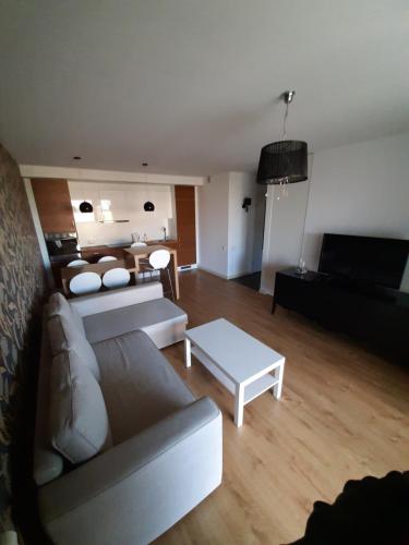 uma sala de estar com um sofá e uma mesa em Apartament Klif em Władysławowo