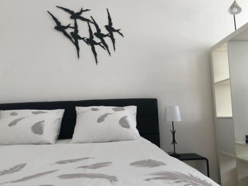 - une chambre dotée d'un lit avec des feuilles sur le mur dans l'établissement Hyper-Centre historique avec possibilité de réservation parking, à Toulouse