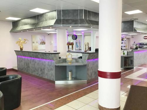 a lobby with a bar with purple and gray at Hôtel Angelic in Lourdes