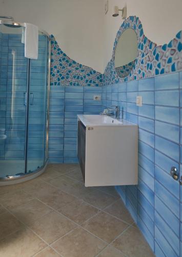 a blue bathroom with a sink and a shower at Maiori Dream House 1 in Maiori